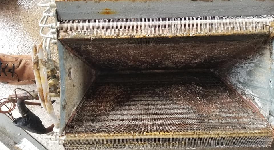 A close up of a rusty machine with a tattoo on a person 's arm.