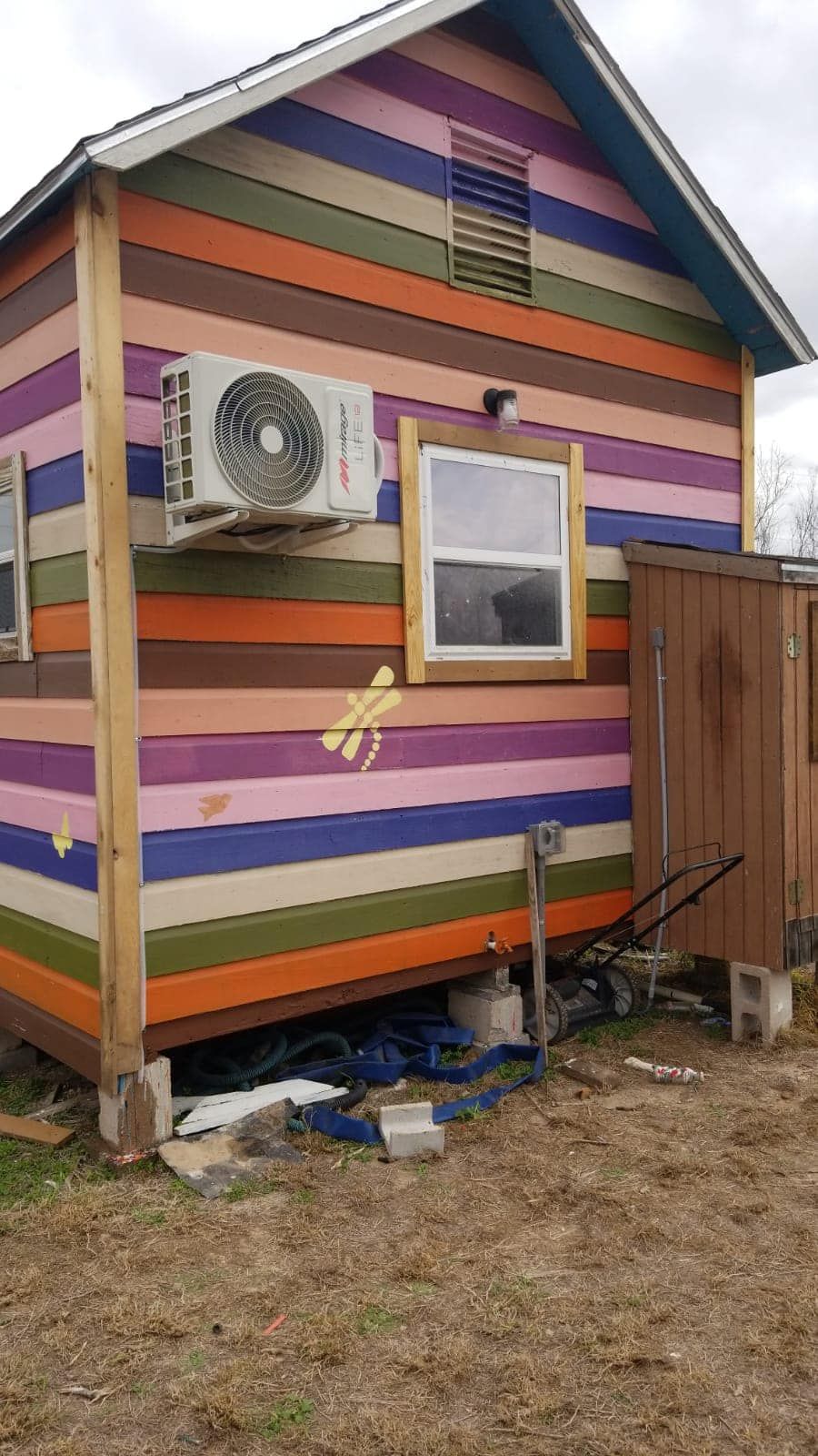 A colorful house with a fan on the side of it.