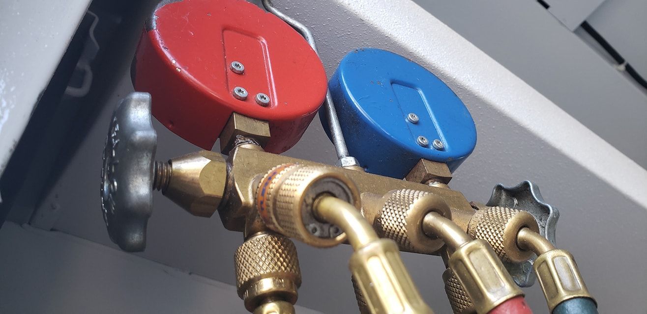 A close up of a valve with two gauges attached to it.