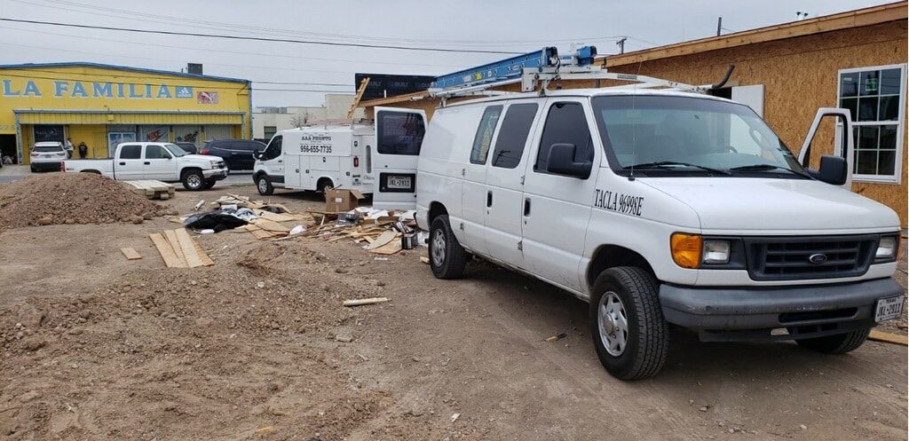 A white van is parked in front of a building under construction.