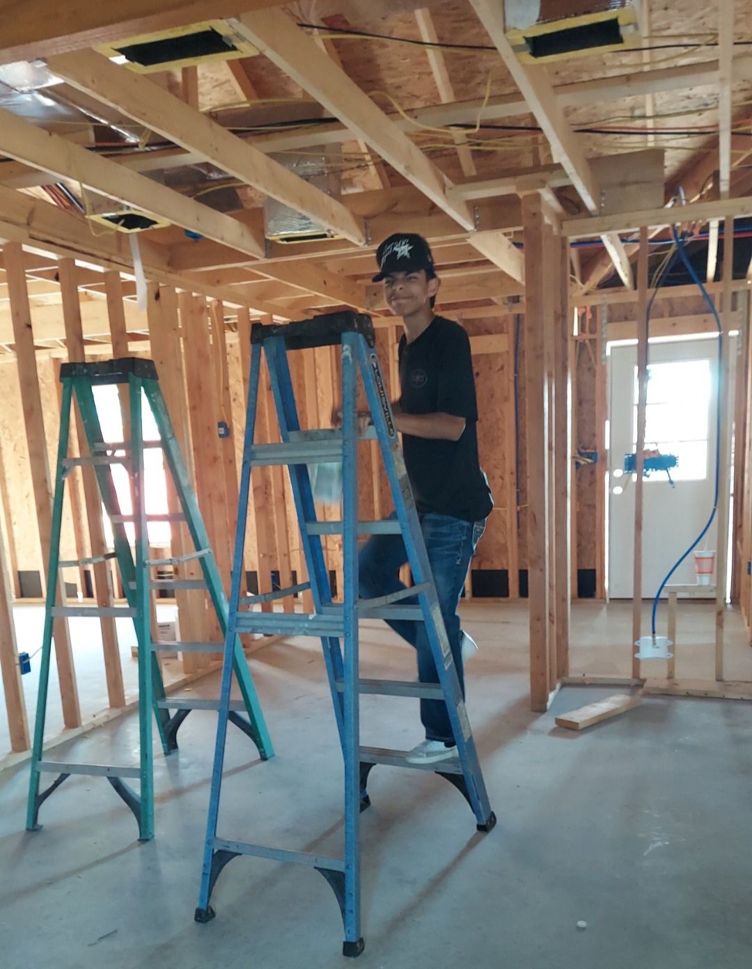 A man is holding a yellow device in front of an air conditioner