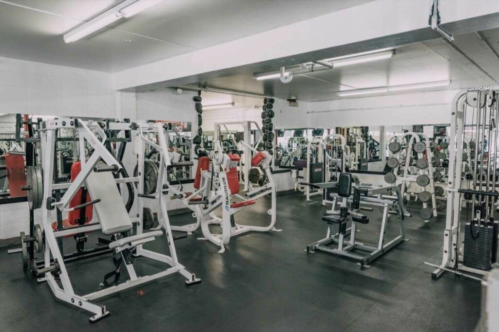 A large gym filled with lots of exercise equipment.