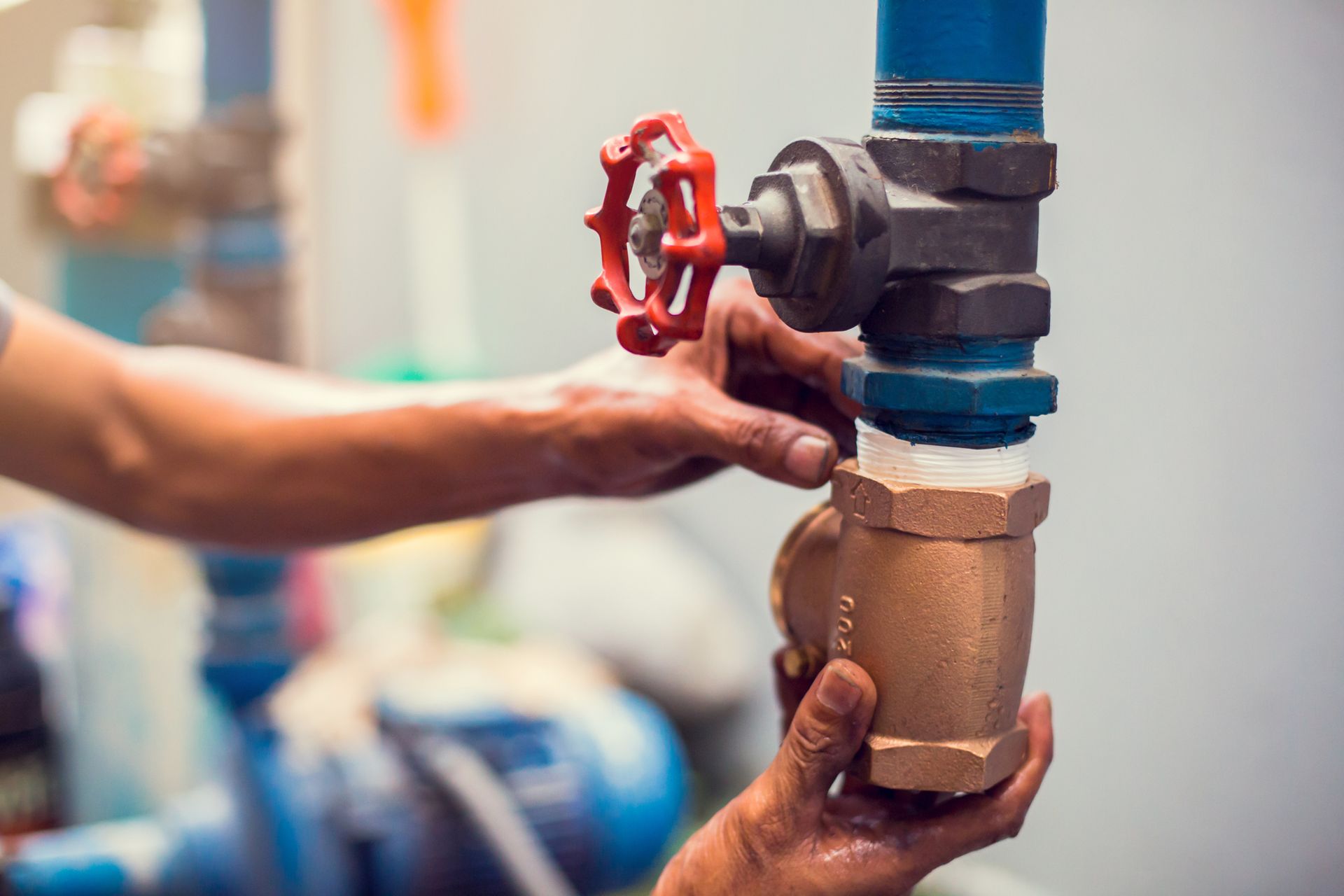 Close-up of a plumber's hands as it repairs as it removes and repairs a water supply valve.
