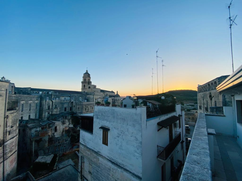 Una vista di una città da un balcone al tramonto.