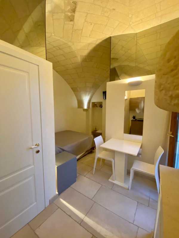 Una camera da letto con un letto, un tavolo e delle sedie