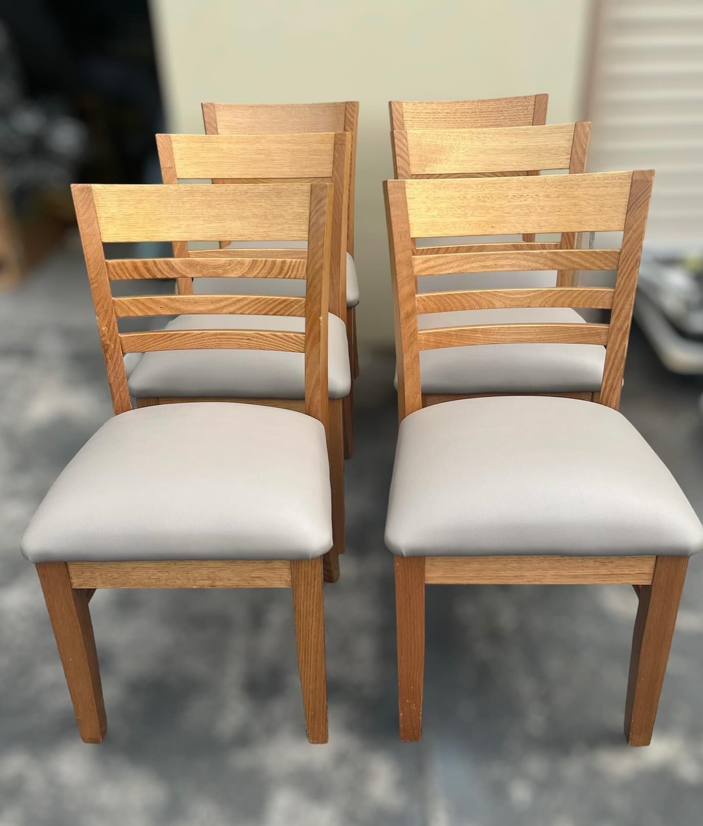 A row of wooden chairs with white seats — Metreson Upholstery In Unanderra, NSW