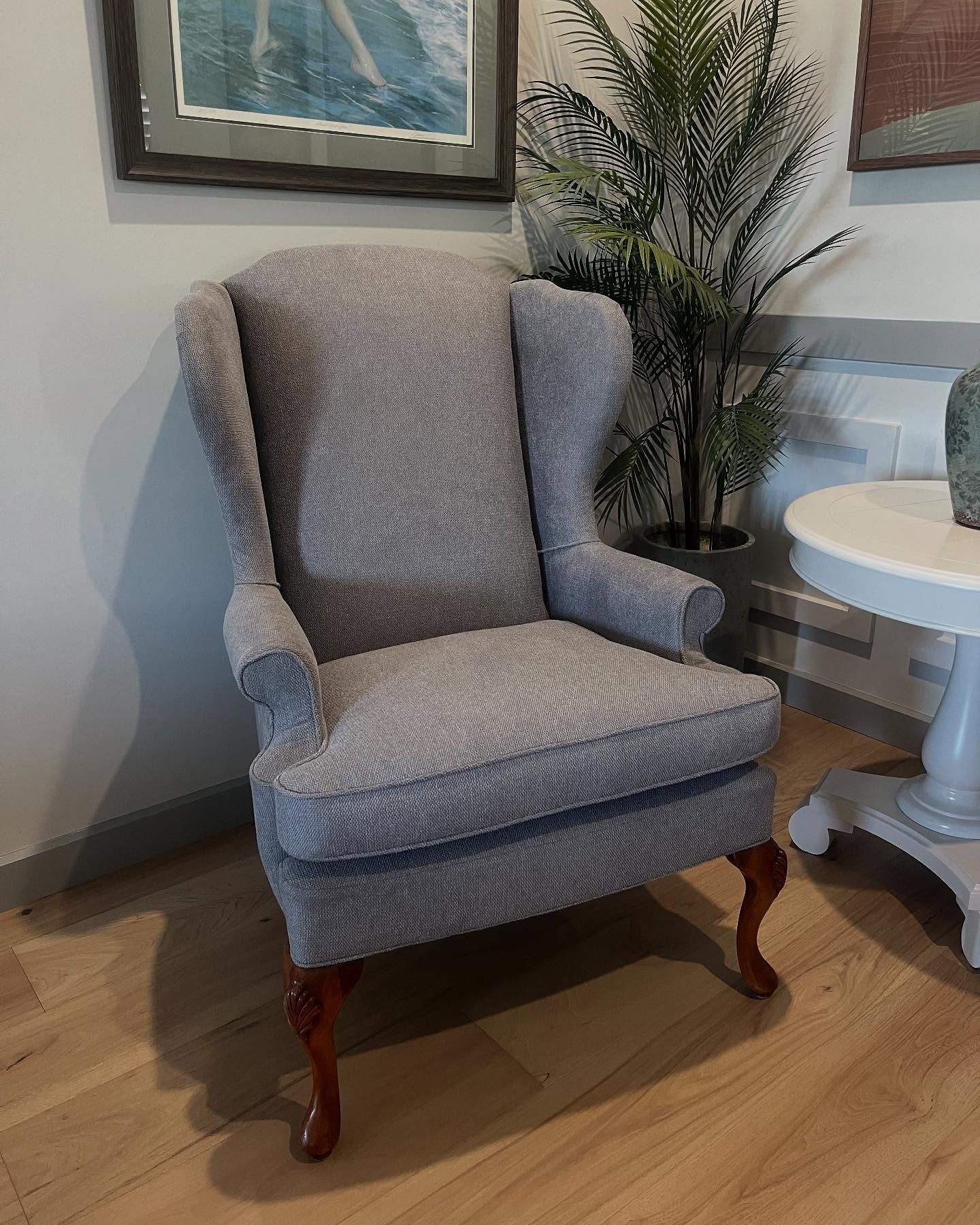 A grey chair is sitting in a living room next to a table — Metreson Upholstery In Unanderra, NSW