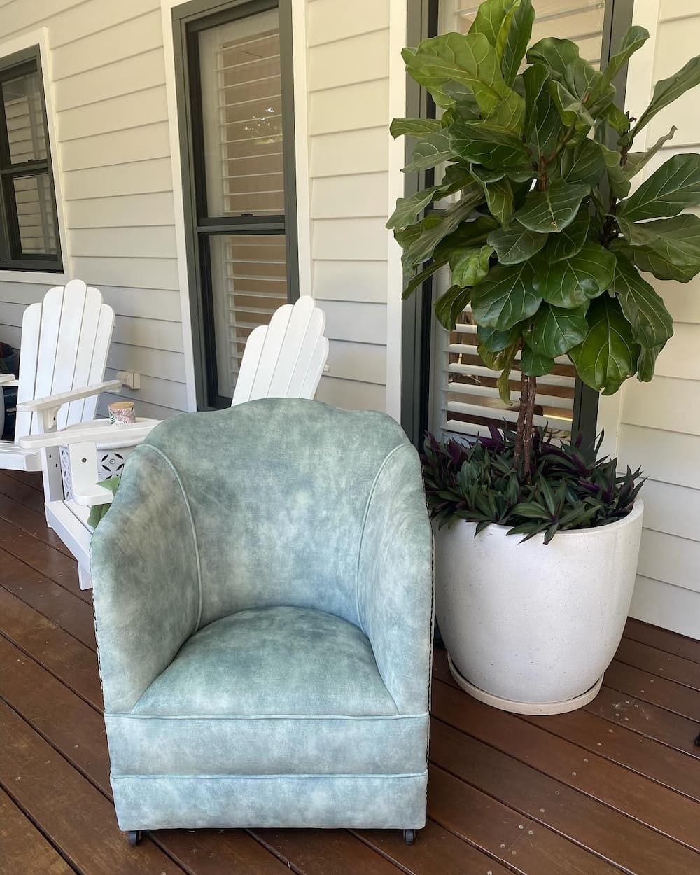 A Light Blue Upholstered Armchair Sits on A Wooden Porch — Metreson Upholstery In Unanderra, NSW