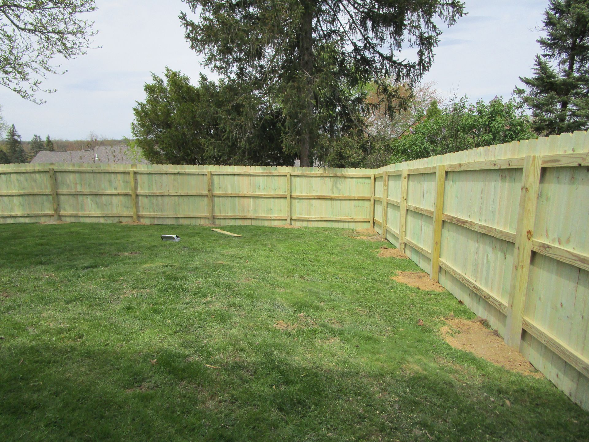 A wooden fence surrounds a lush green lawn in a backyard — Somerset, PA — Stoltzfus Fence