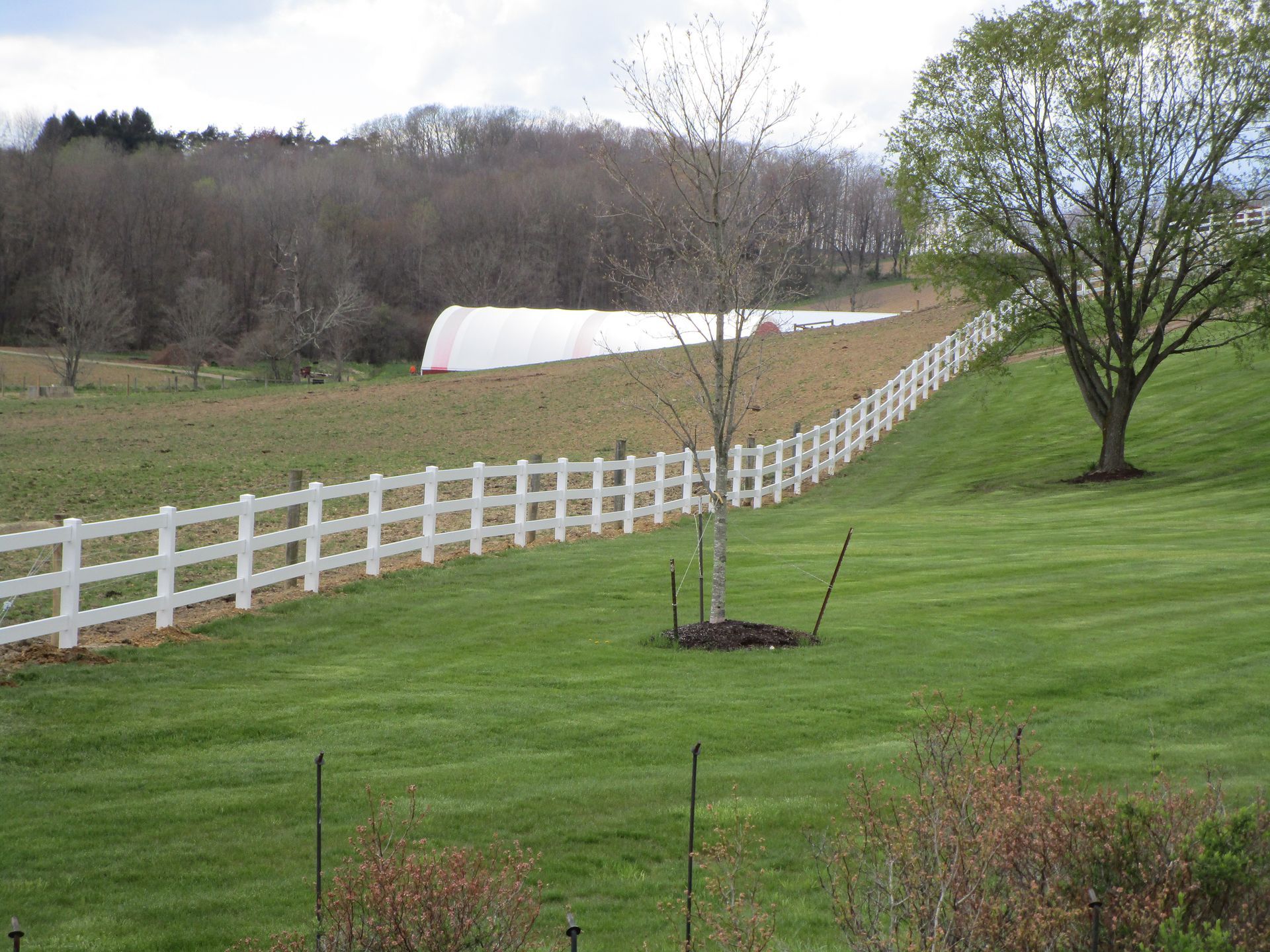 A white fence surrounds a lush green field — Somerset, PA — Stoltzfus Fence