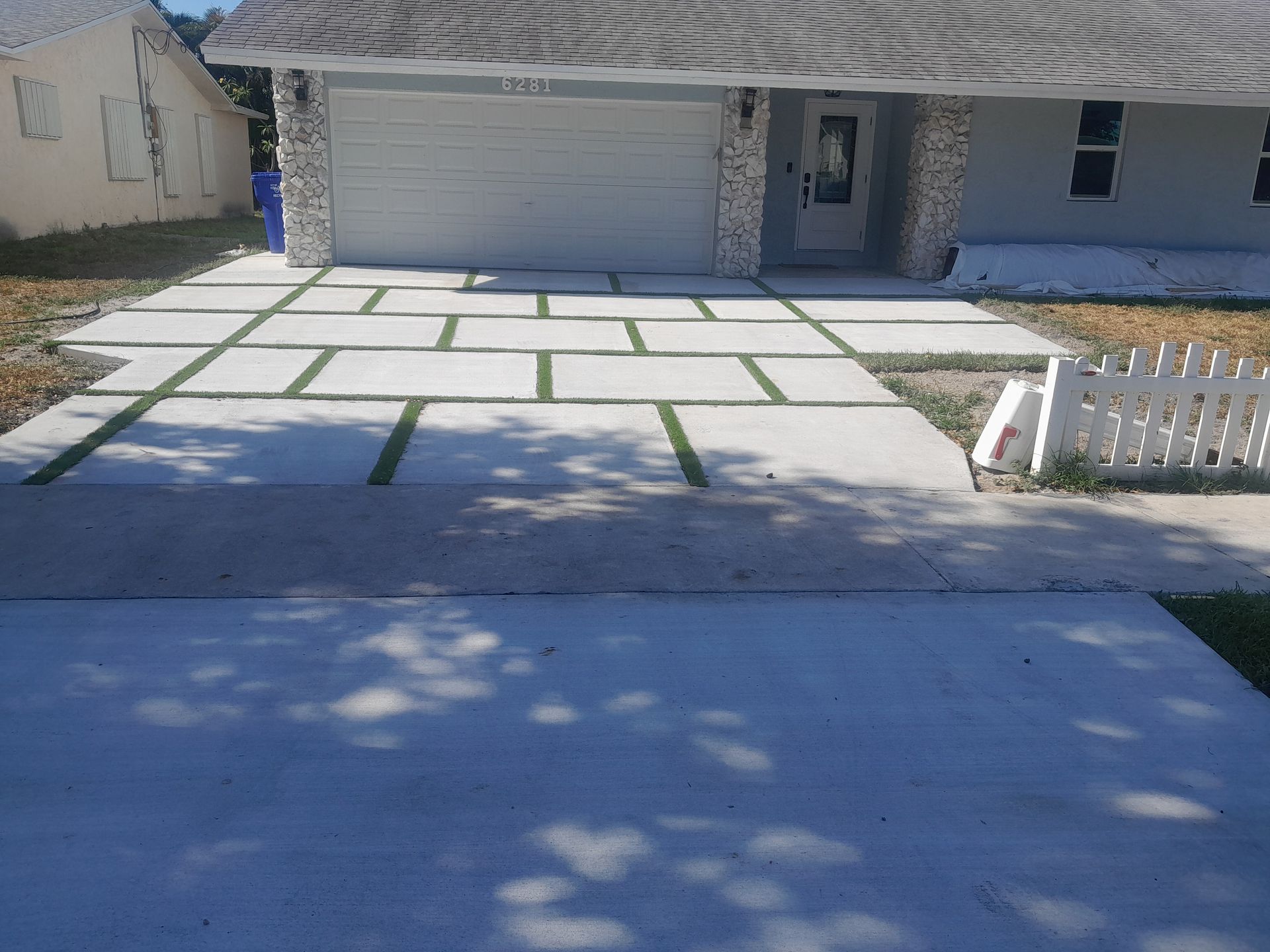 Concrete driveway with grass-filled rectangular inlays leading to a house in Parkland FL