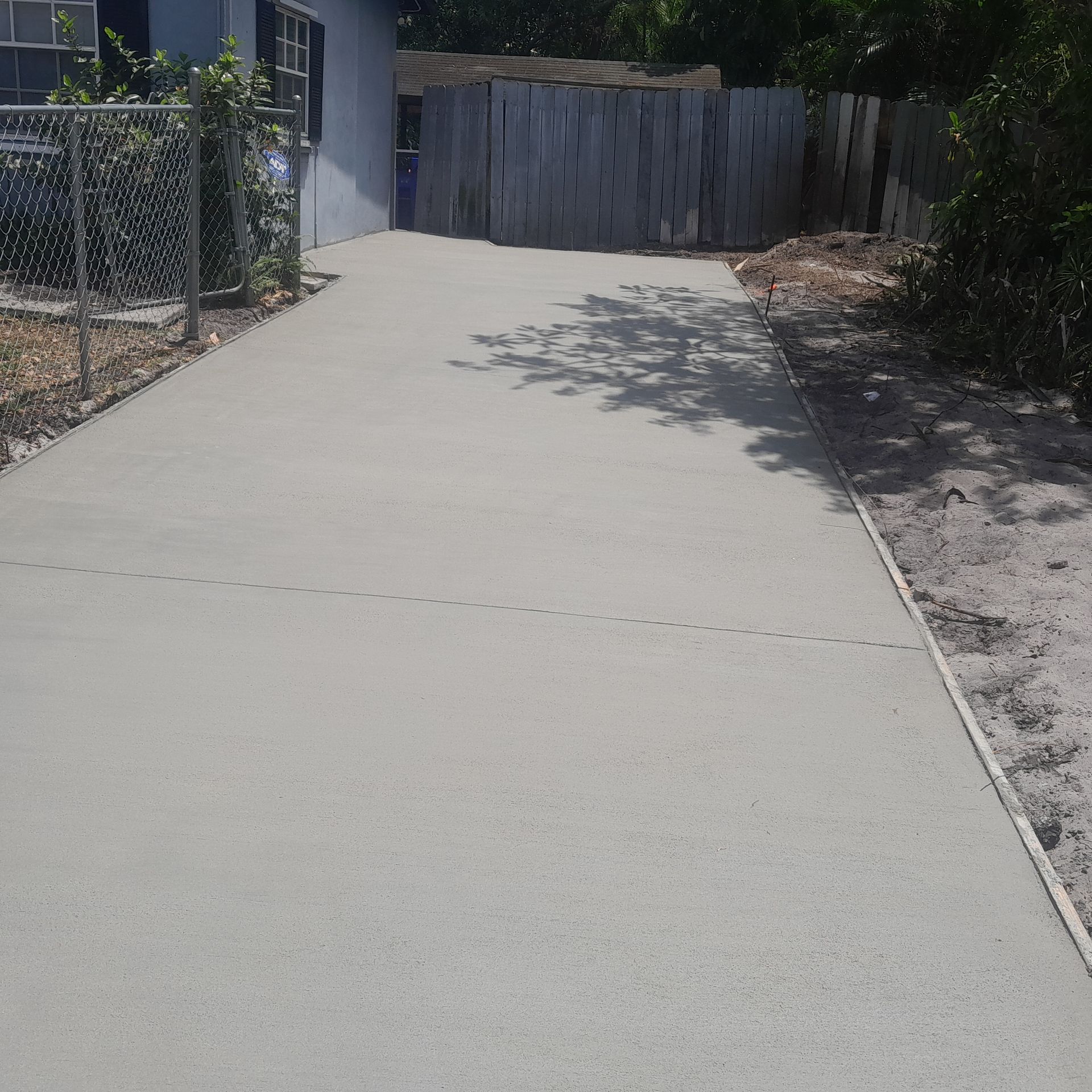 Newly poured concrete driveway leading to a building in Parkland FL