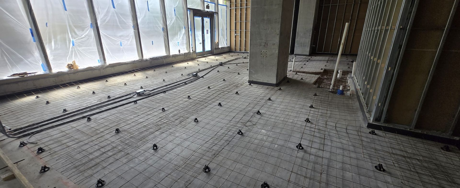 Concrete floor with metal rebar, spacers, and partial window in Parkland FL