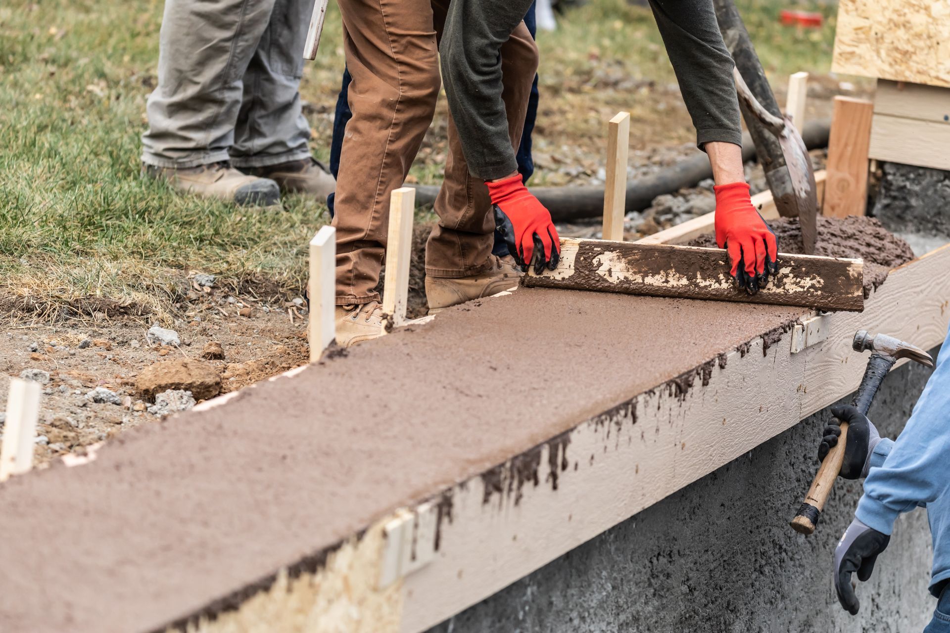 A group of people are working on a concrete walkway.