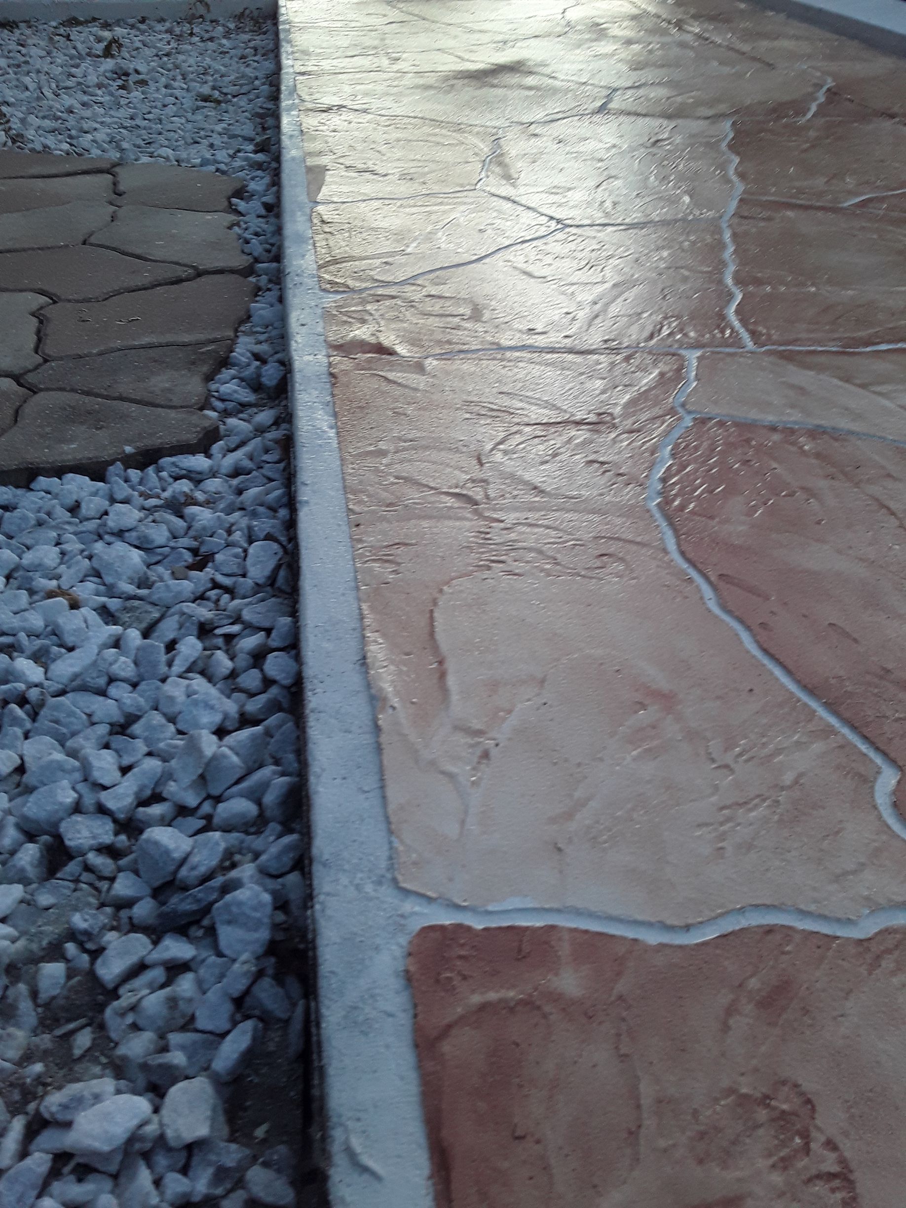 A close up of a stone walkway next to a pile of gravel