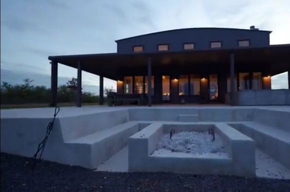 A large house with a fire pit in front of it