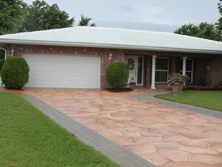 A brick house with a white roof and a driveway