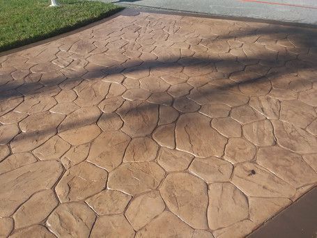 A concrete driveway with a shadow of a tree on it.