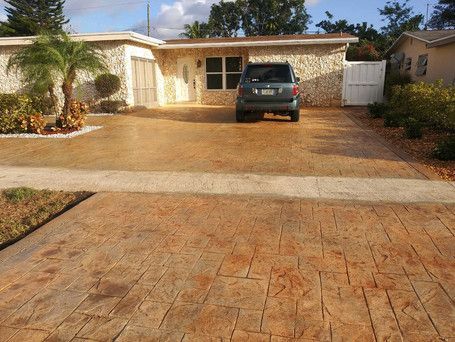 A car is parked in a driveway in front of a house