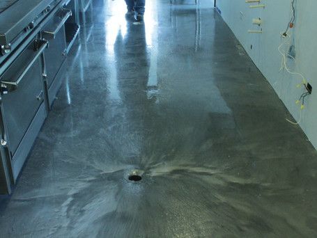 A kitchen floor with a hole in the middle of it