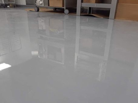 A white floor with a reflection of boxes on it in a room.