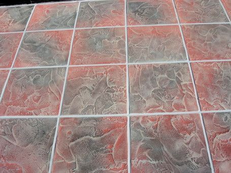 A close up of a tiled floor with red and gray tiles