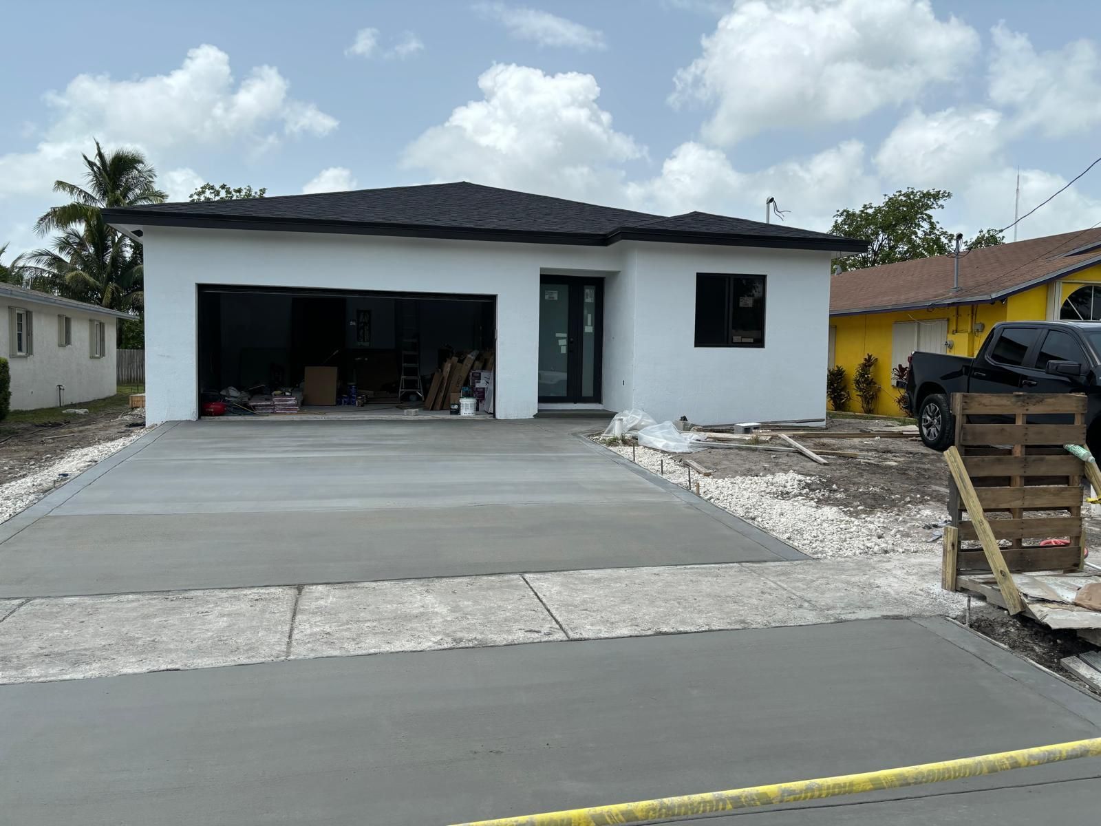 A white house with a concrete driveway in front of it.
