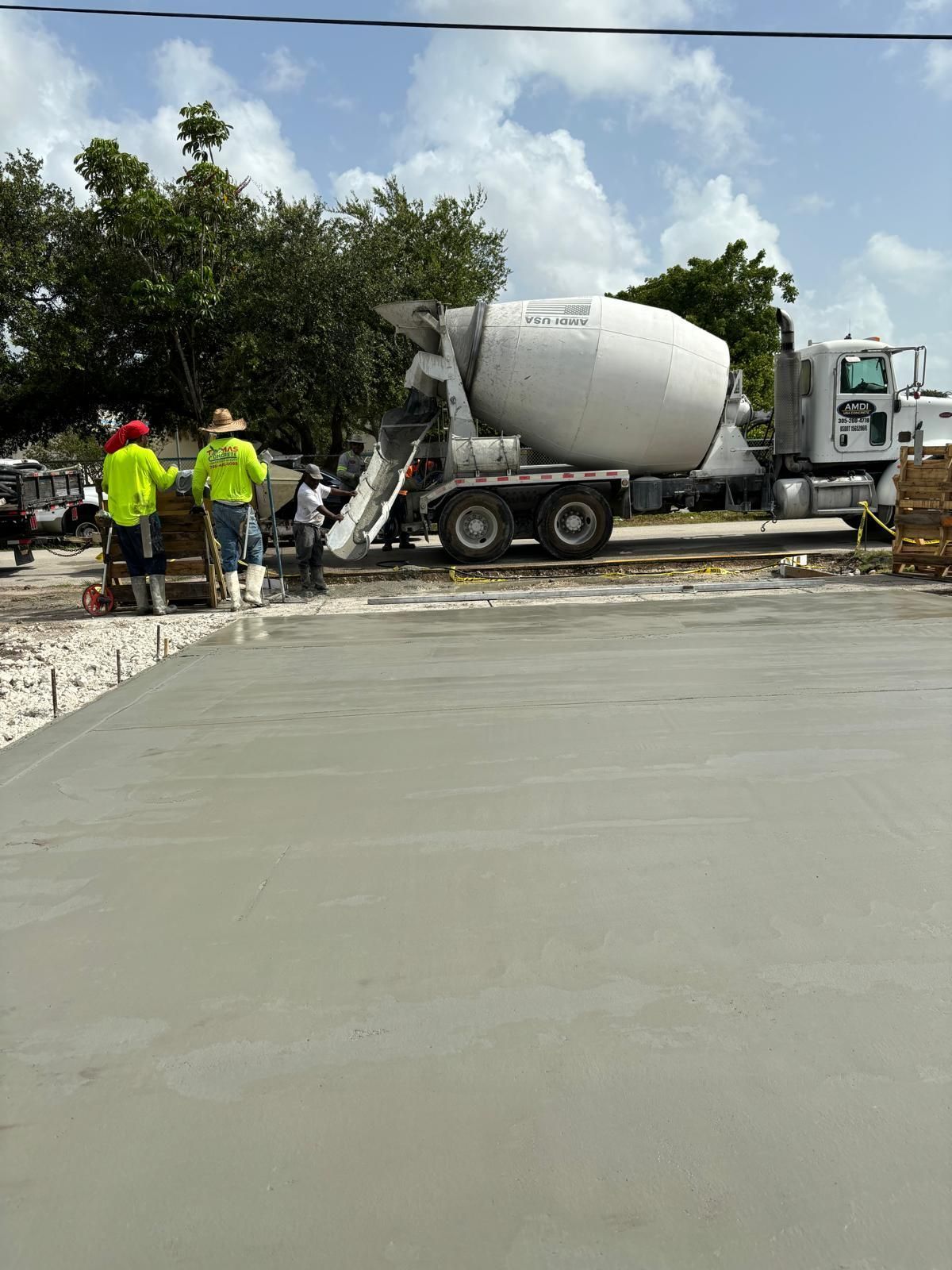 A concrete mixer truck is pouring concrete on a construction site.