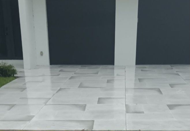 A white tiled driveway with a black garage door in the background.