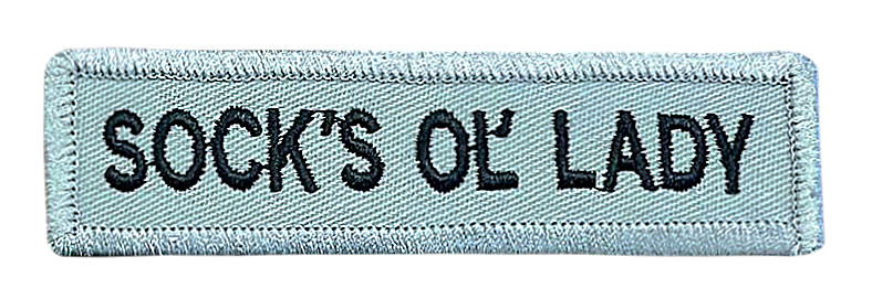 A patch that says socks ok lady on it
