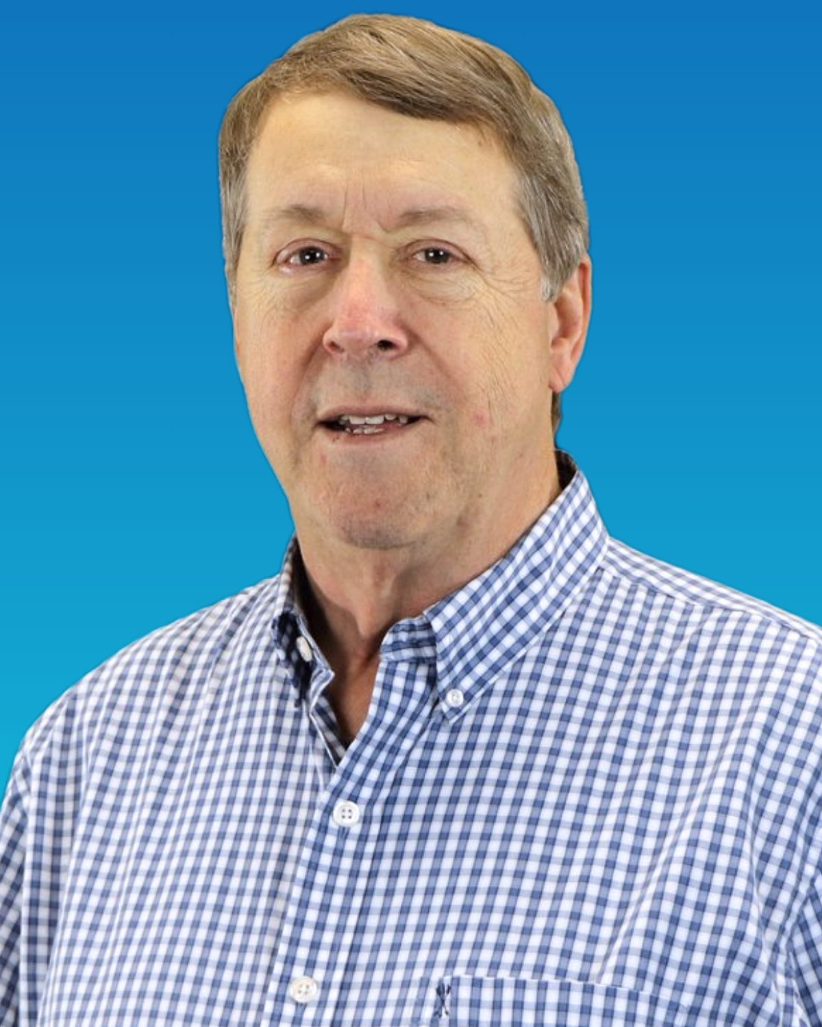 A man wearing a blue and white checkered shirt is standing in front of a blue background.