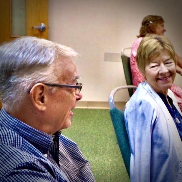 A man and a woman are sitting in chairs and smiling