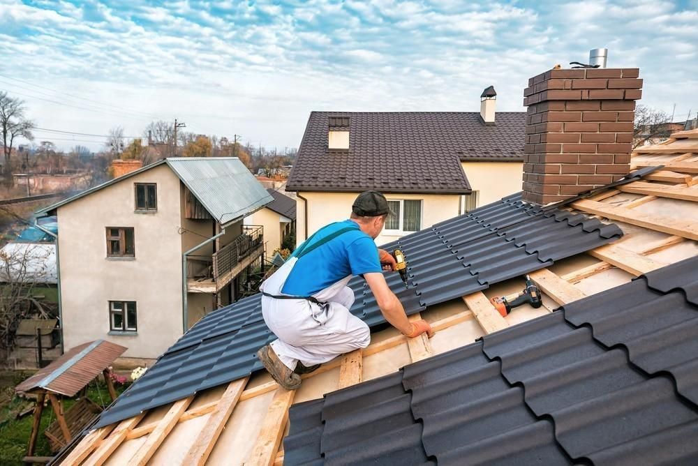 A man is working on the roof of a house.