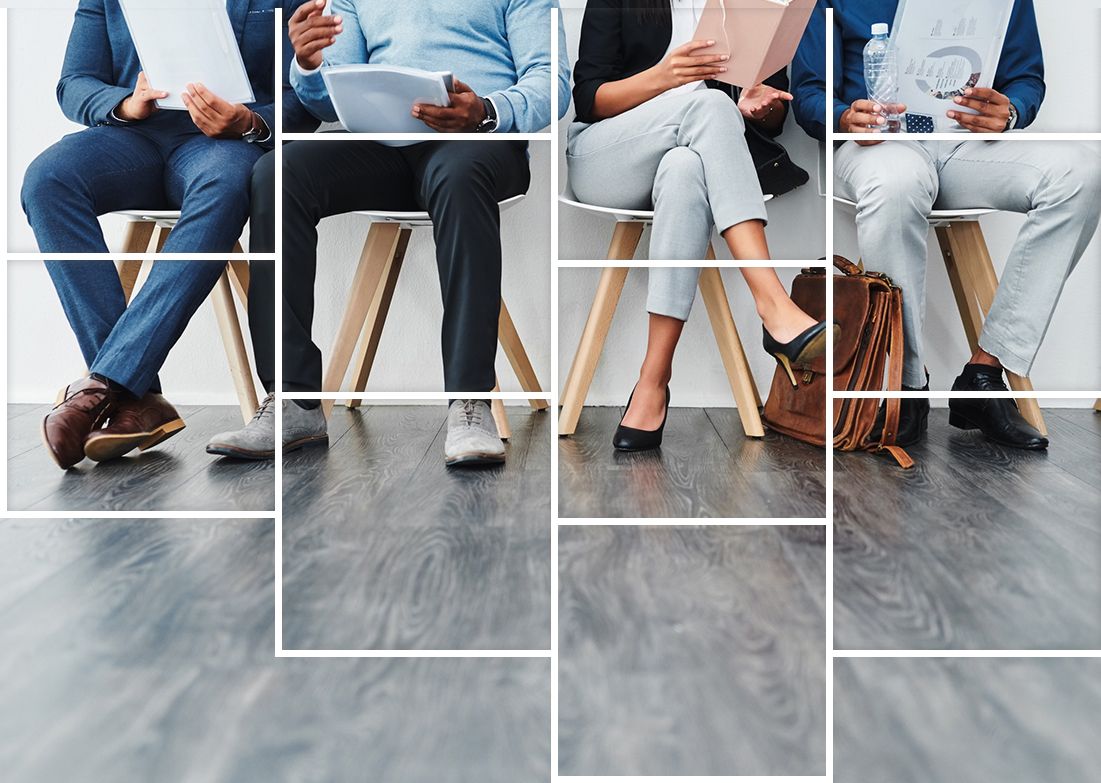 A group of people are sitting in chairs waiting for a job interview.