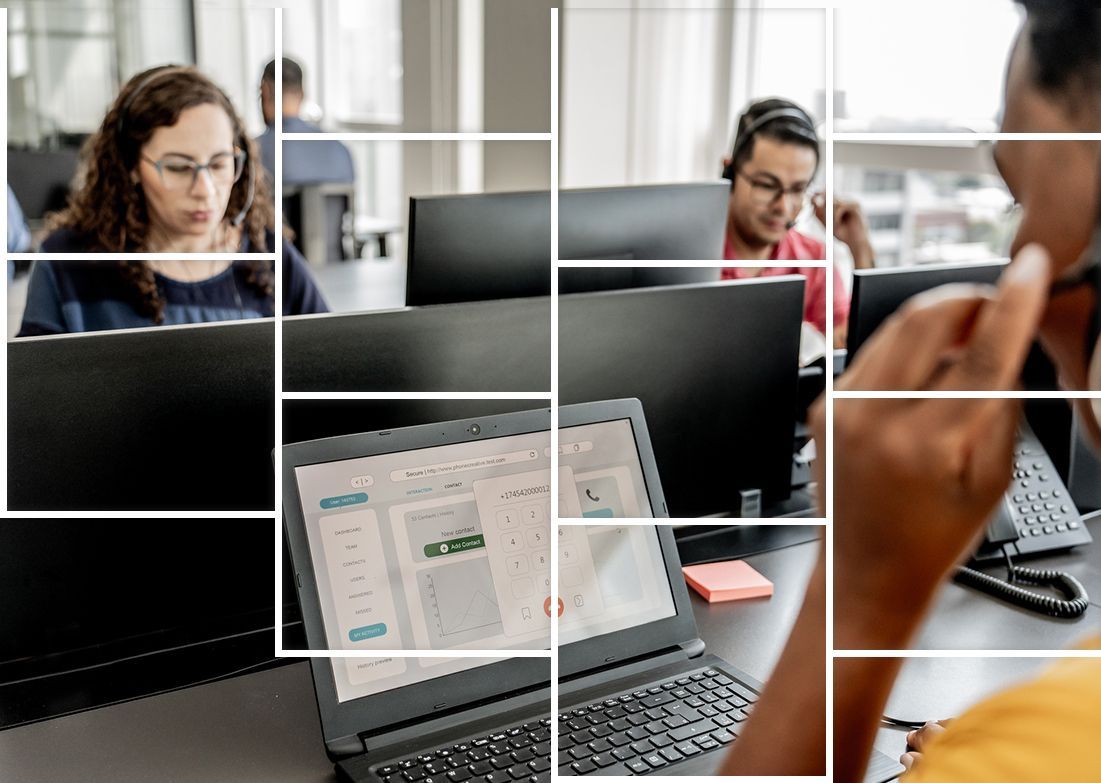 A group of people are sitting at desks in front of laptops.