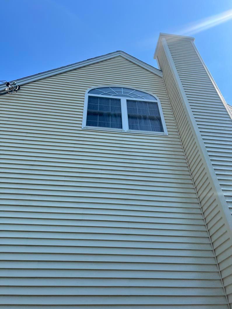 A house with a chimney and a window on the side of it.