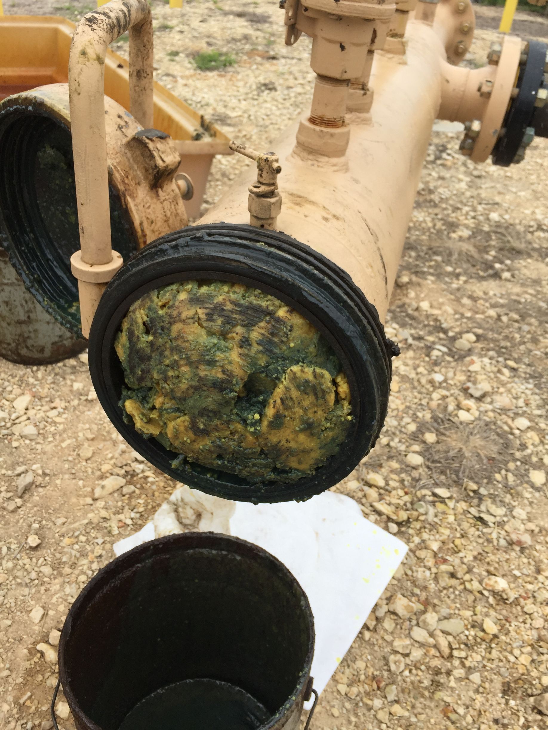 Pipeline pigging opening showing heavy wax buildup inside pipeline before cleaning