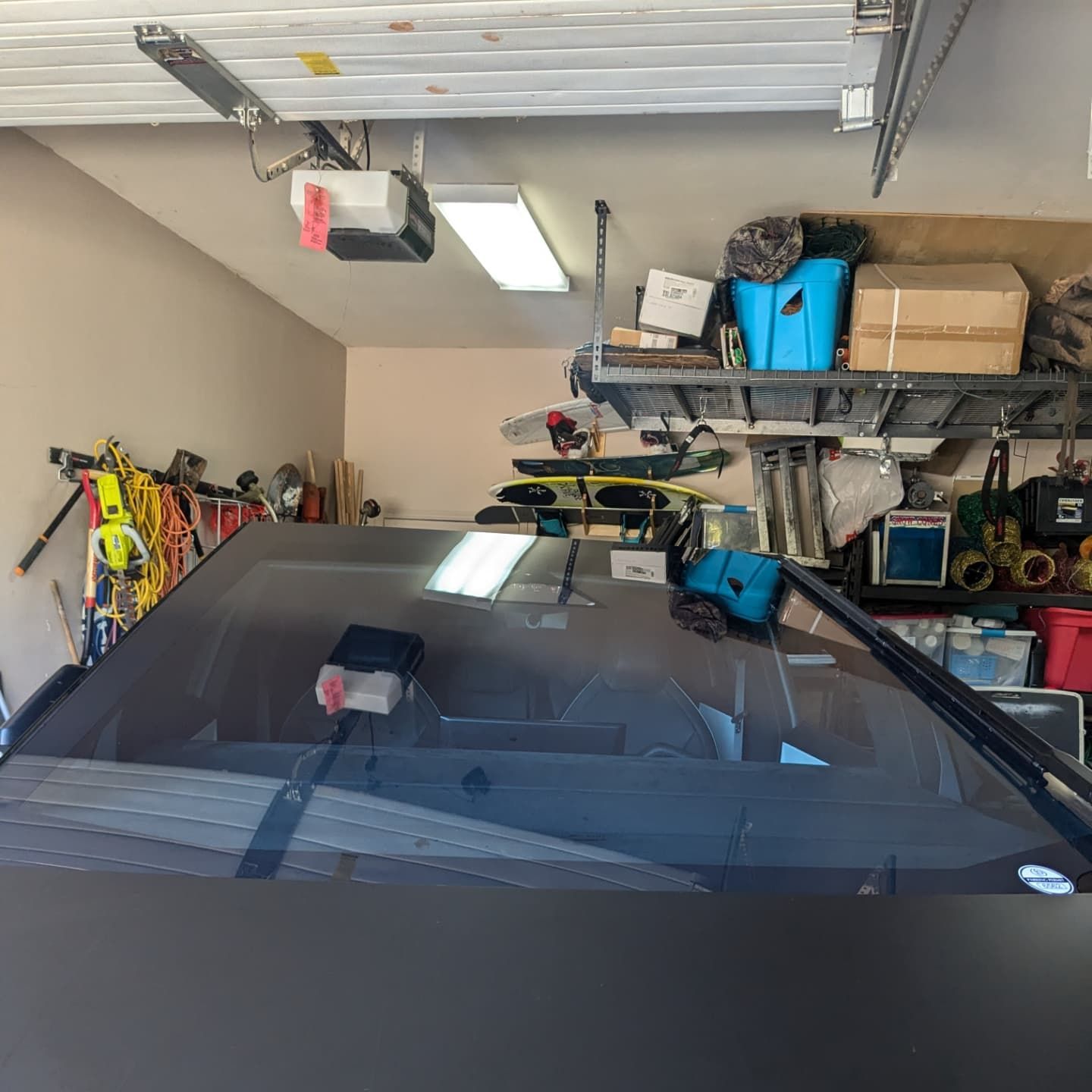 A car is parked in a garage with a garage door open.