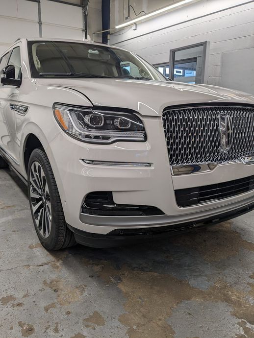 A white lincoln aviator is parked in a garage.