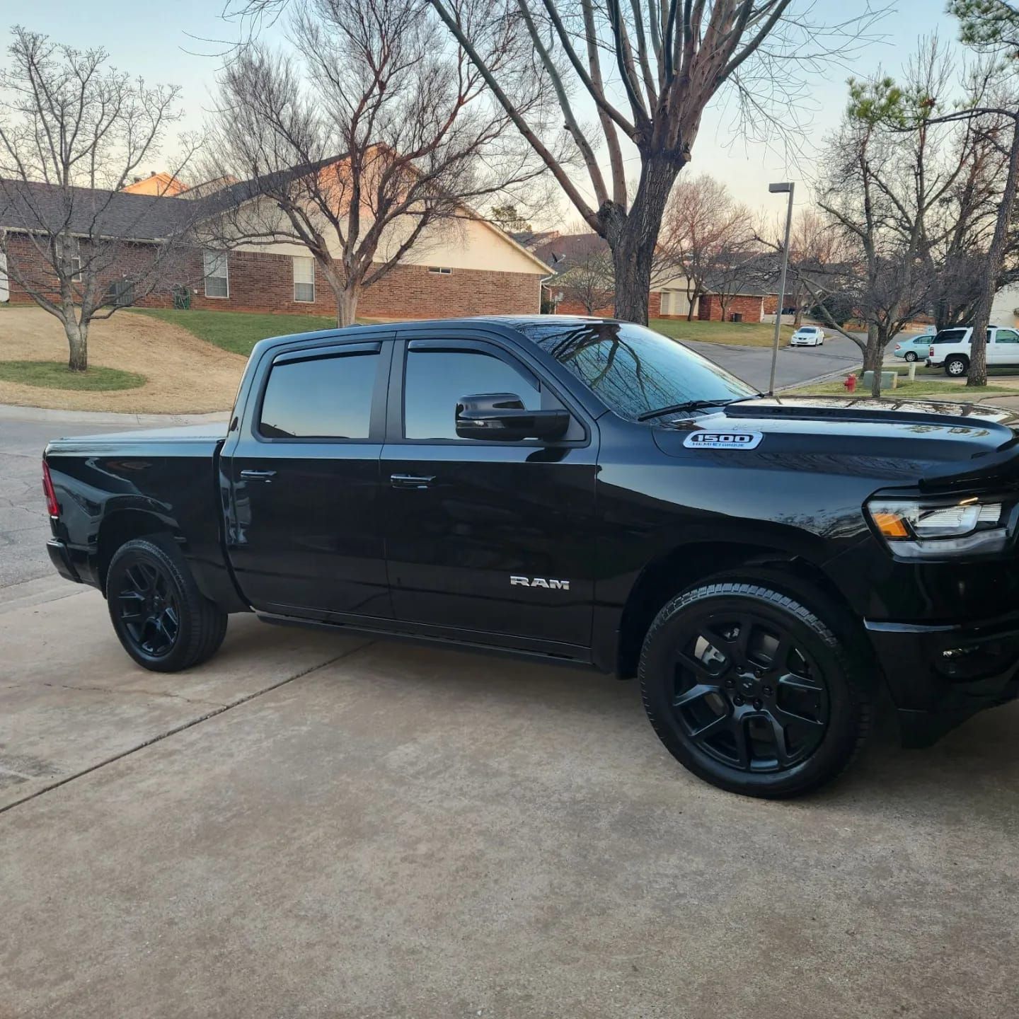 A black dodge ram truck is parked on the side of the road.