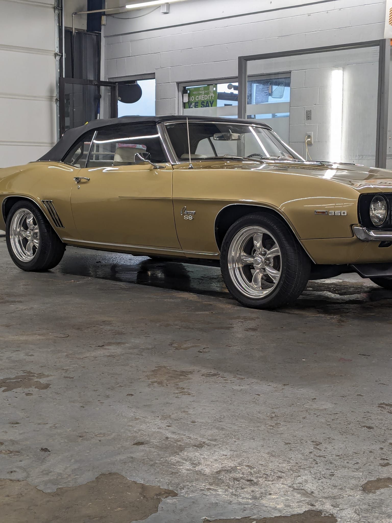 A gold car is parked in a garage.