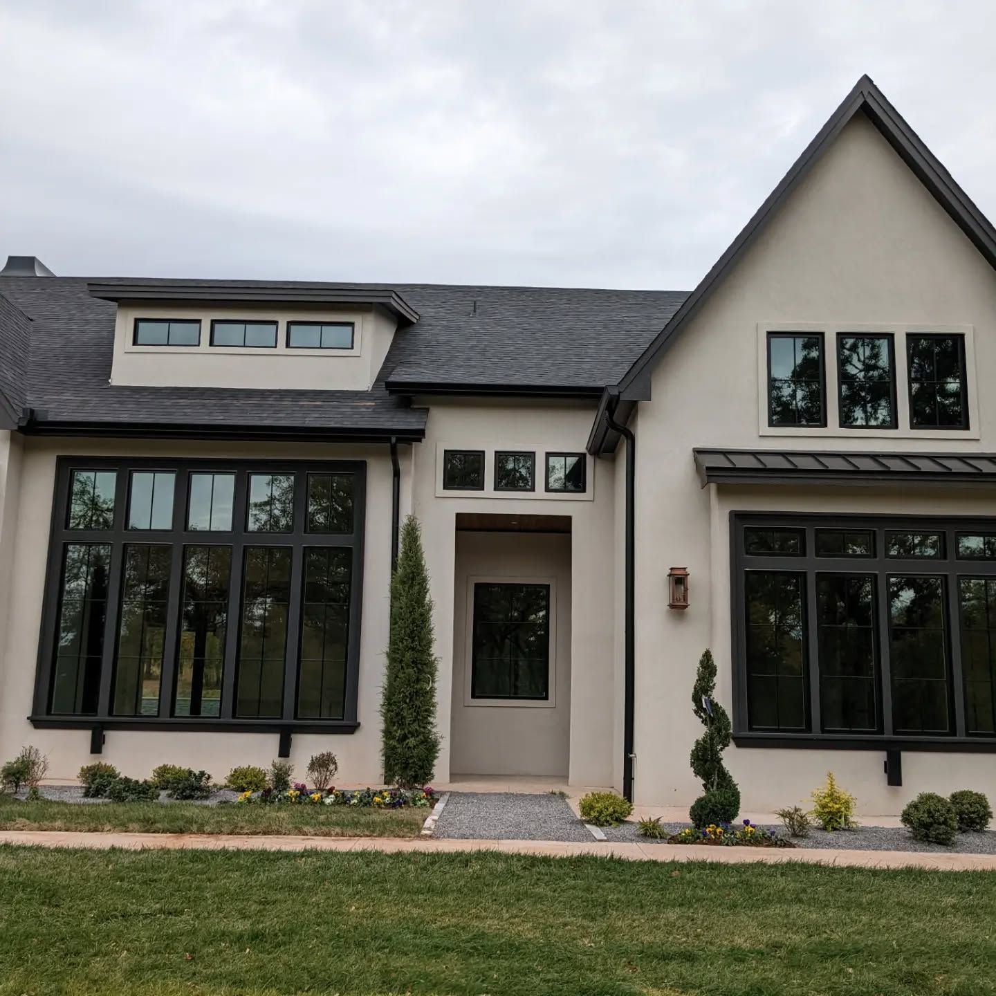 A white house with a black roof and lots of windows