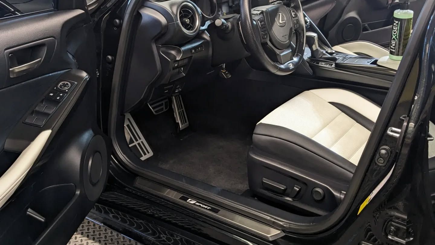 The inside of a black car with the door open.