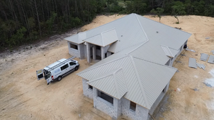 handyman using nail gun to install shingle to repair roof

