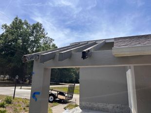 selective focus of handsome handyman repairing roof with coworker

