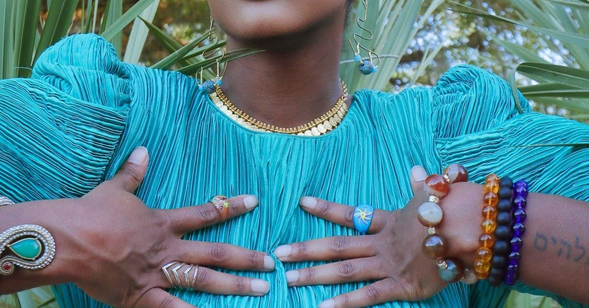 Une femme en robe bleue tient sa poitrine avec ses mains.