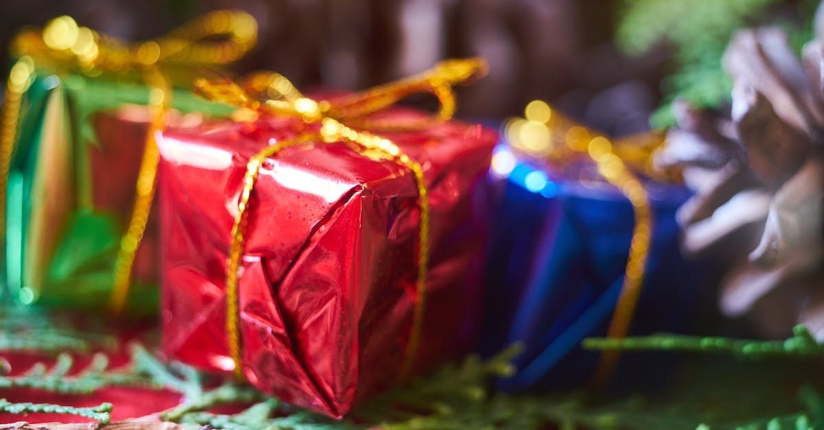 Un groupe de cadeaux de Noël emballés dans du papier d'aluminium coloré sont posés sur une table.