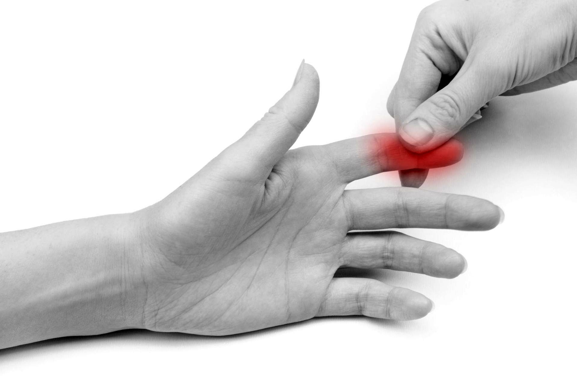 black and white photo of a hand pinching the tip of someone's index finger that is in pain