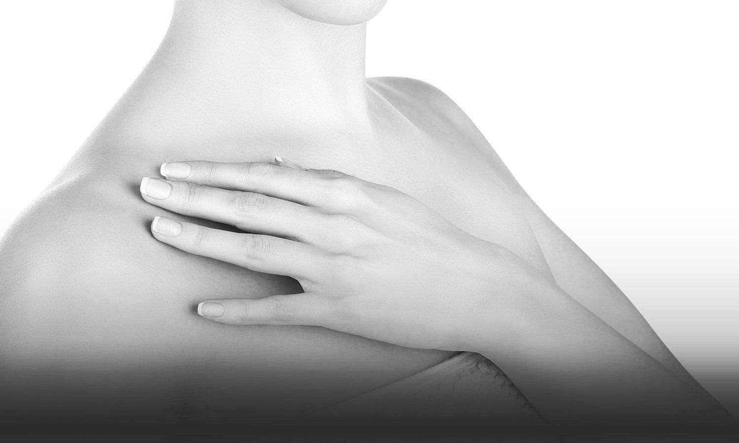 black and white photo of a woman holding hand over her collarbone