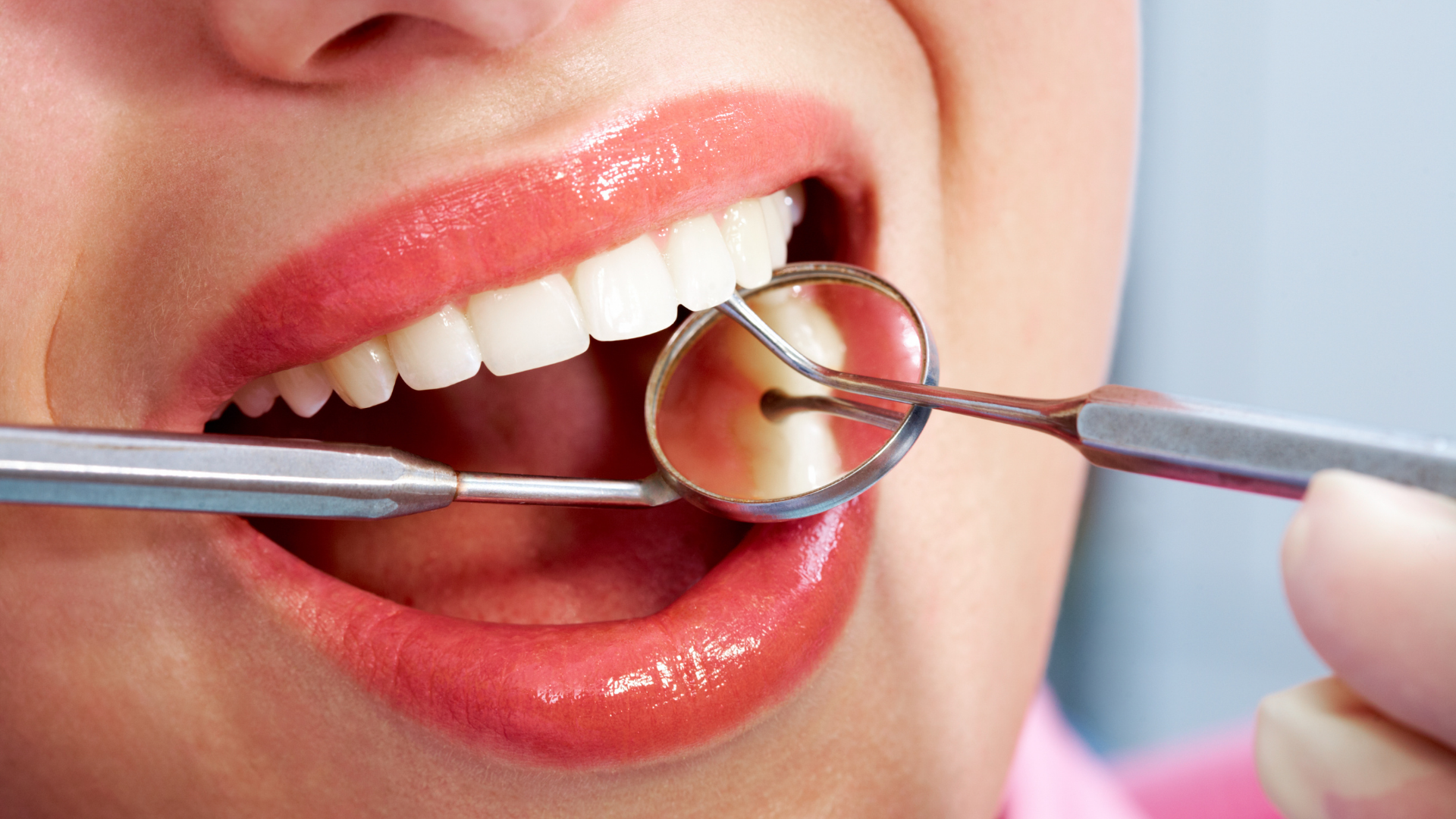 A woman is getting her teeth examined by a dentist.